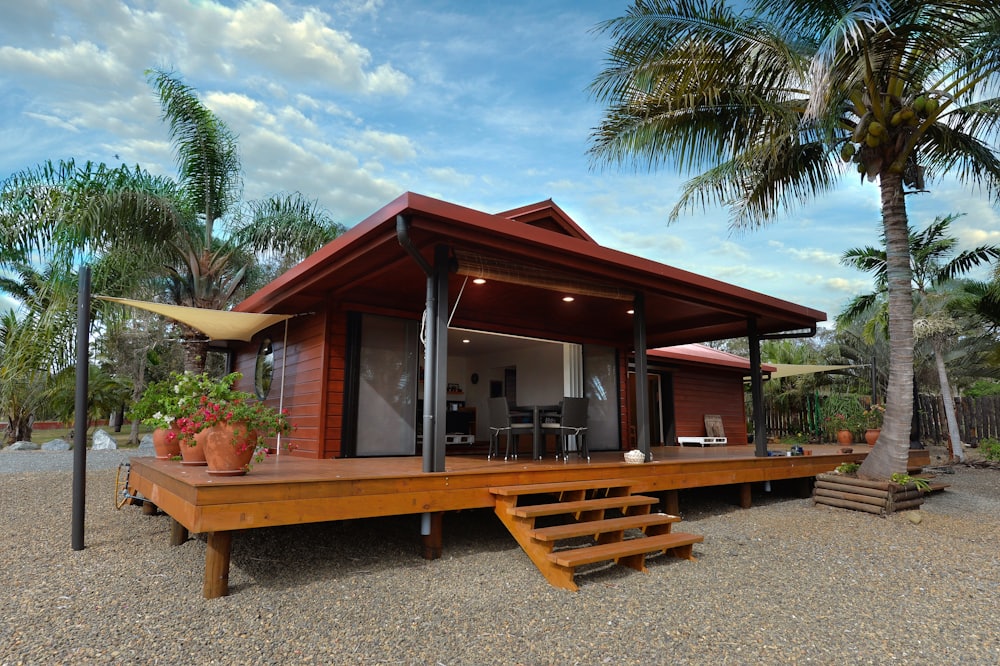 Wooden chalet with a deck and palm trees